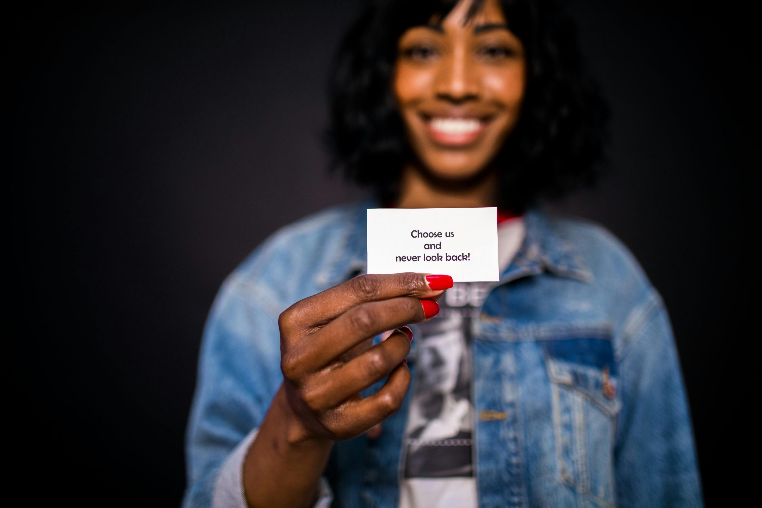 A smiling woman holds an inspirational card with the message 'Choose us and never look back!'